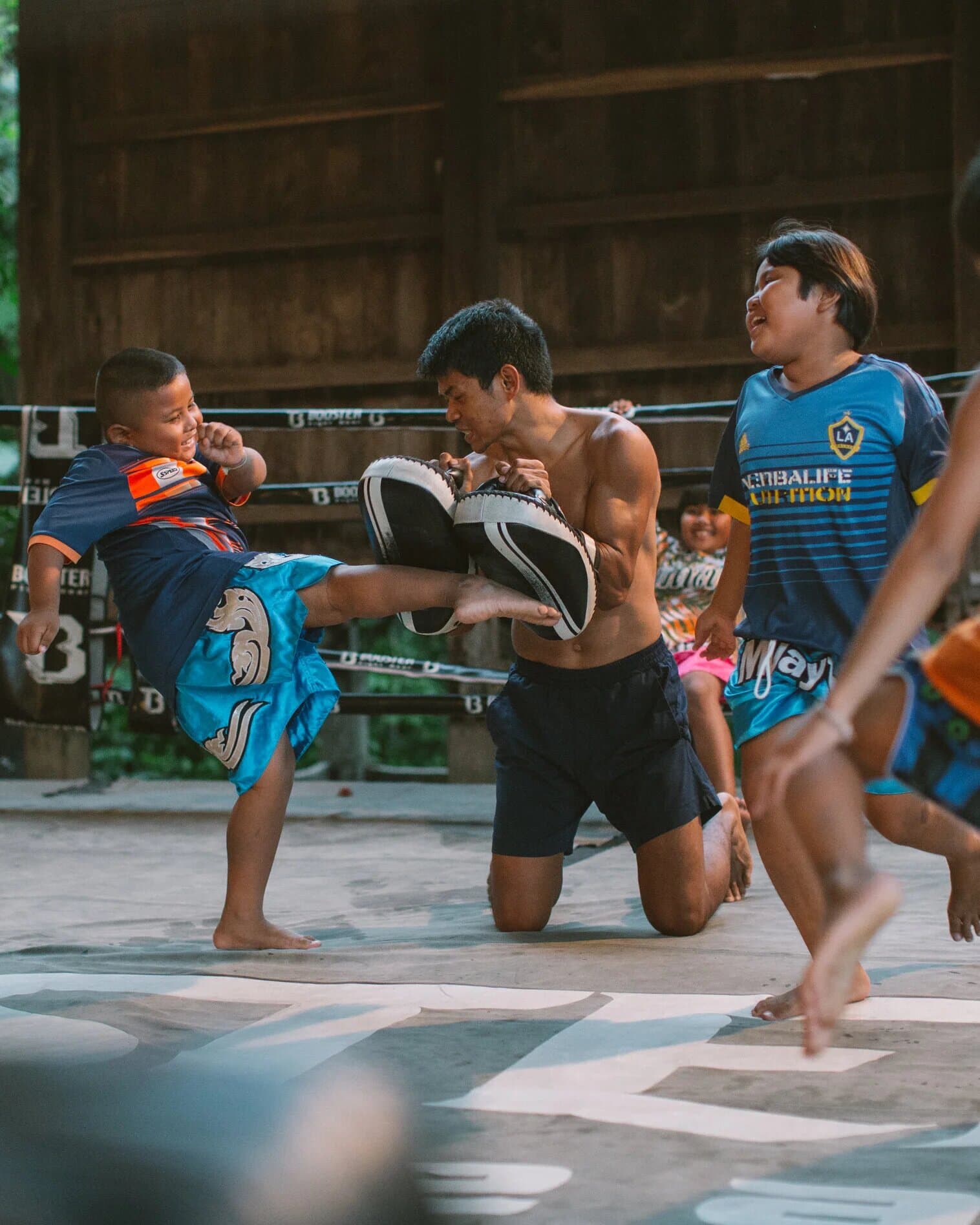 Kids training Muay Thai with a coach in the ring at Wor Watthana gym in rural Thailand